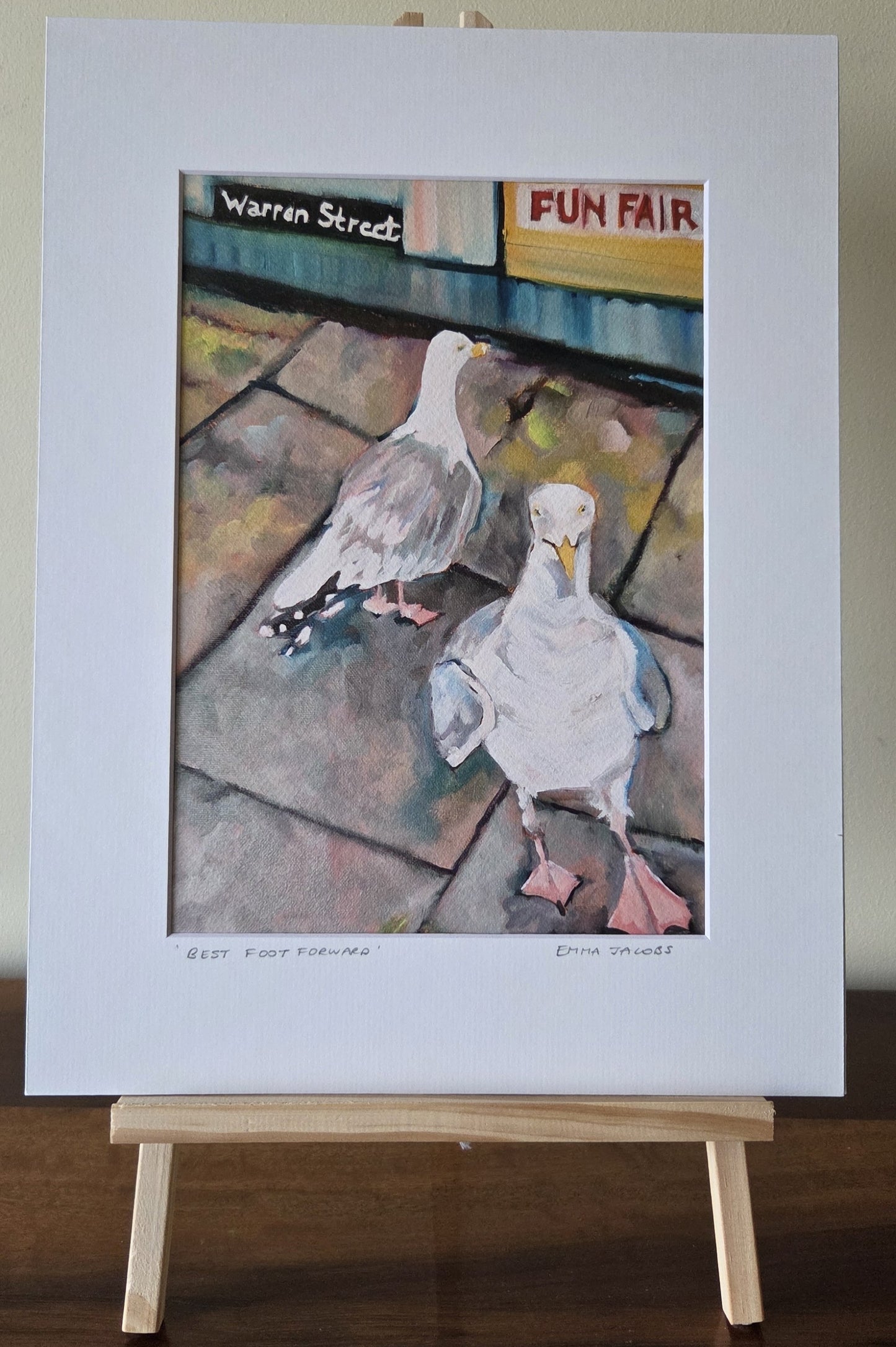 Art print of two seagulls on a stone pavement with 'Warren Street Fun Fair' sign in the background, by Emma Jacobs