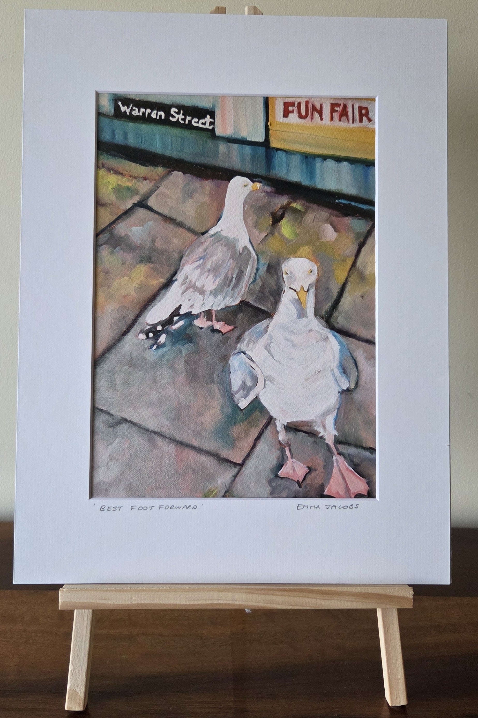 Art print of two seagulls on a stone pavement with 'Warren Street Fun Fair' sign in the background, by Emma Jacobs