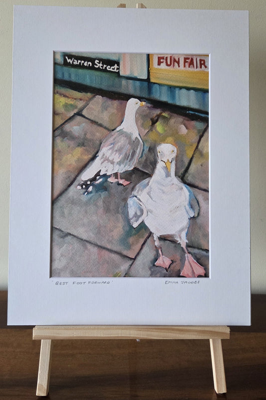 Art print of two seagulls on a stone pavement with 'Warren Street Fun Fair' sign in the background, by Emma Jacobs